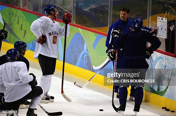 Finland ice hockey players listen to head coach Jukka Jalonen's instructions during a practice session at the Canada Hockey Place in Vancouver two...