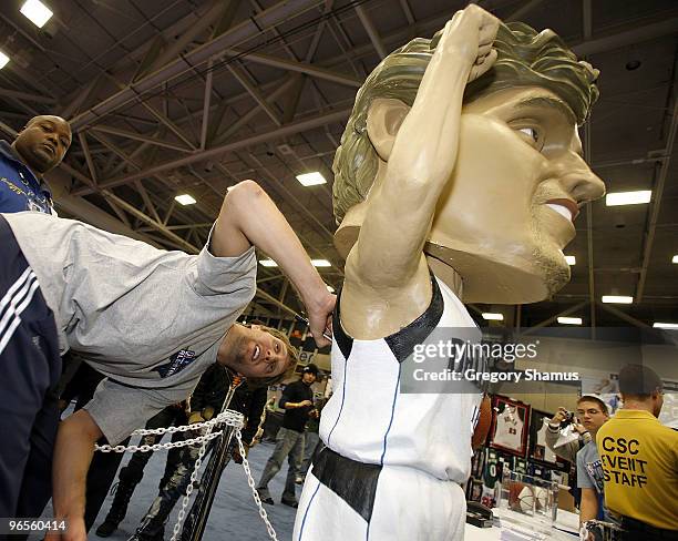 Dirk Nowitzki of the Dallas Mavericks autographs a life size bobblehead during a appearance at Jam Session presented by Adidas during NBA All Star...