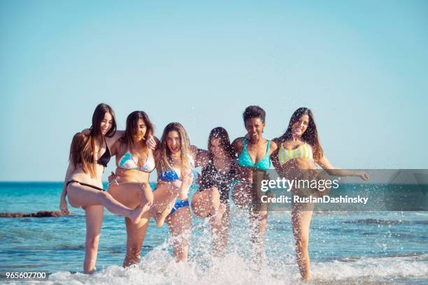 chicas verano divirtiéndose en las salpicaduras de agua. - girls sunbathing fotografías e imágenes de stock