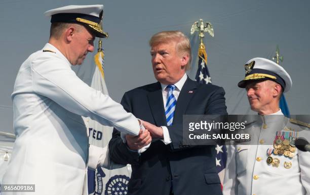 President Donald Trump shakes hands with Admiral Karl Schultz as he is installed as the Commandant of the US Coast Guard from Admiral Paul Zukunft...