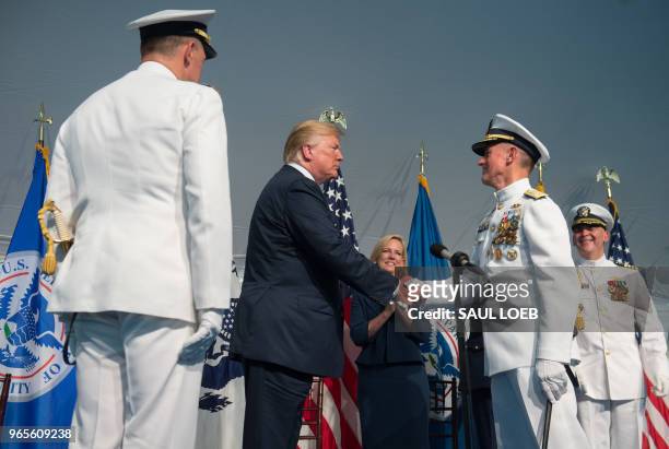 President Donald Trump shakes hands with Admiral Paul Zukunft as he retires during a Change of Command ceremony as Admiral Karl Schultz takes over as...