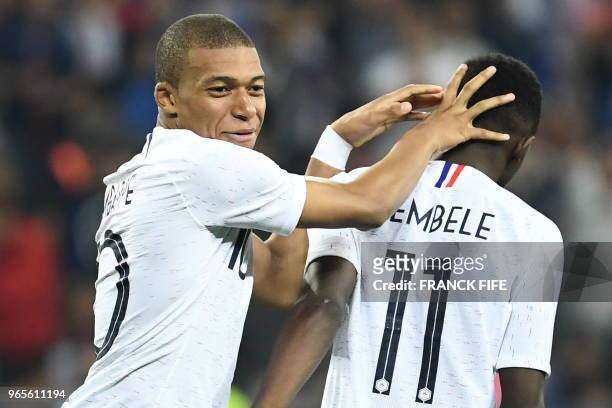France's foward Kylian Mbappe reacts with France's foward Ousmane Dembele during the friendly football match between France and Italy at the Allianz...