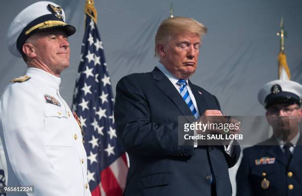 President Donald Trump looks on next to Admiral Paul Zukunft as he retires as Commandant of the US Coast Guard during a Change of Command ceremony as...