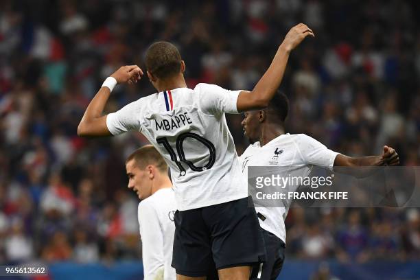 France's foward Ousmane Dembele celebrates with France's foward Kylian Mbappe after scoring a goal during the friendly football match between France...