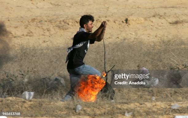 Palestinian carries a burning bucket after Israeli security forces' intervention along the Gaza-Israel border during From Gaza to Haifa: Unity of...