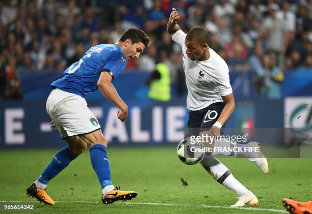 France's foward Kylian Mbappe vies for the ball with Italy's defender Mattia Caldara during the friendly football match between France and Italy at...