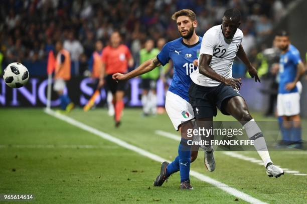 France's midfielder Benjamin Mendy vies for the ball with Italy's forward Domenico Berardi during the friendly football match between France and...