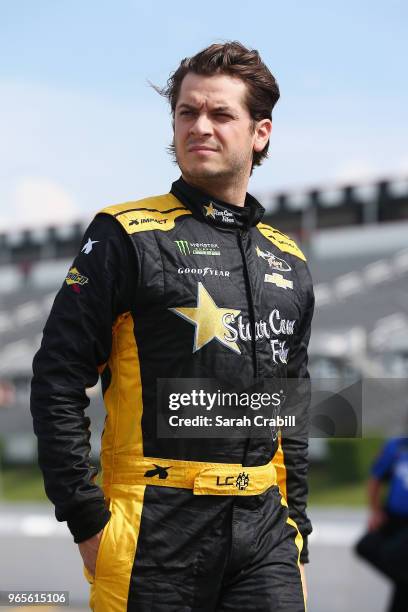 Landon Cassill, driver of the TW Cable LLC Chevrolet, walks on the grid during qualifying for the Monster Energy NASCAR Cup Series Pocono 400 at...