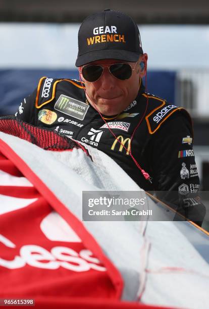 Jamie McMurray, driver of the GEARWRENCH Chevrolet, climbs into his car during qualifying for the Monster Energy NASCAR Cup Series Pocono 400 at...