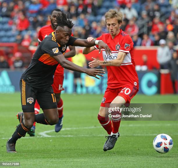 Alberth Elis of the Houston Dynamo tries to get around Daniel Johnson of the Chicago Fire at Toyota Park on May 20, 2018 in Bridgeview, Illinois. The...