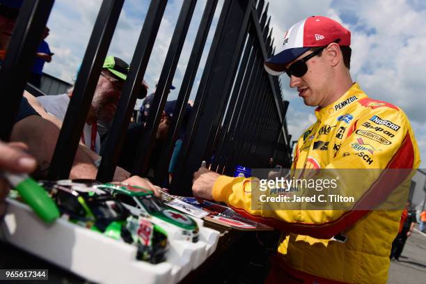 Joey Logano, driver of the Shell Pennzoil Ford, signs autographs after qualifying for the Monster Energy NASCAR Cup Series Pocono 400 at Pocono...