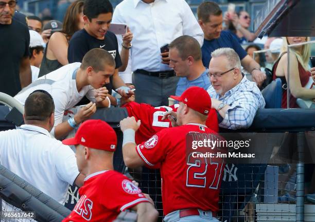 Mike Trout of the Los Angeles Angels of Anaheim signs autographs prior to a game against the New York Yankees at Yankee Stadium on May 25, 2018 in...