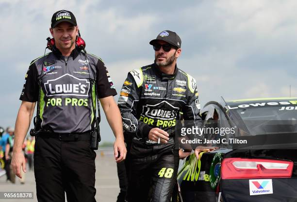 Jimmie Johnson, driver of the Lowe's for Pros Chevrolet, and crew chief, Chad Knaus, walk on the grid during qualifying for the Monster Energy NASCAR...