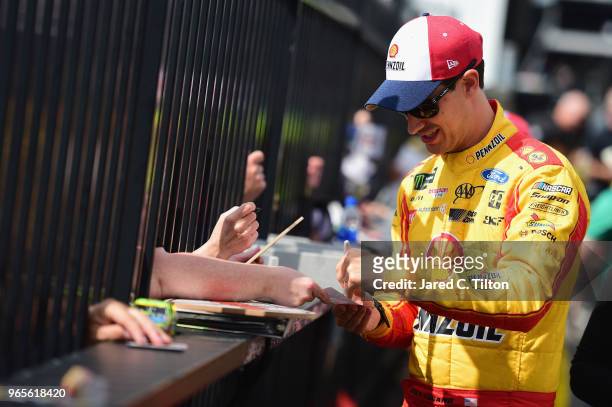 Joey Logano, driver of the Shell Pennzoil Ford, signs autographs after qualifying for the Monster Energy NASCAR Cup Series Pocono 400 at Pocono...