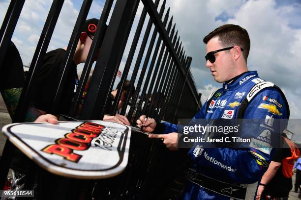 Alex Bowman, driver of the Nationwide Chevrolet, signs autographs during qualifying for the Monster Energy NASCAR Cup Series Pocono 400 at Pocono...