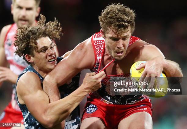 Luke Parker of the Swans is tackled by Charlie Curnow of the Blues during the round 11 AFL match between the Sydney Swans and the Carlton Blues at...