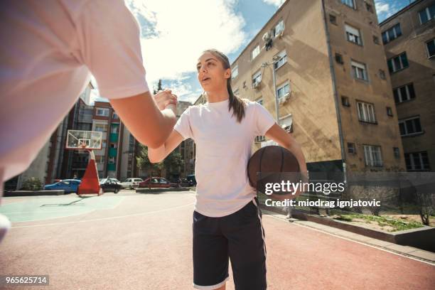 junge schöne frau, die basketball spielen - streetball stock-fotos und bilder