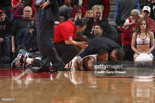 Derrick Rose of the Chicago Bulls talks to team staff after bruising his right hip in a collision with Dwight Howard of the Orlando Magic on February...