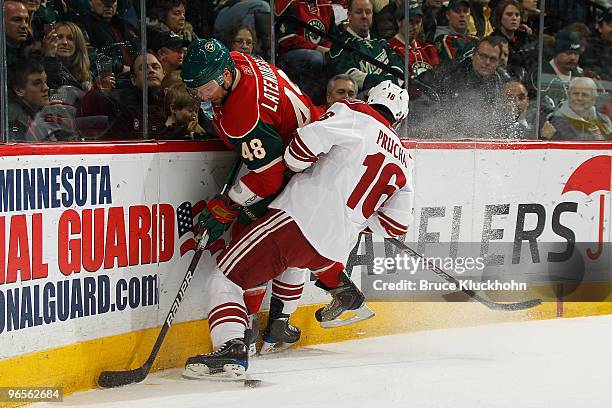 Guillaume Latendresse of the Minnesota Wild collides with Petr Prucha of the Phoenix Coyotes while battling for a loose puck along the boards during...