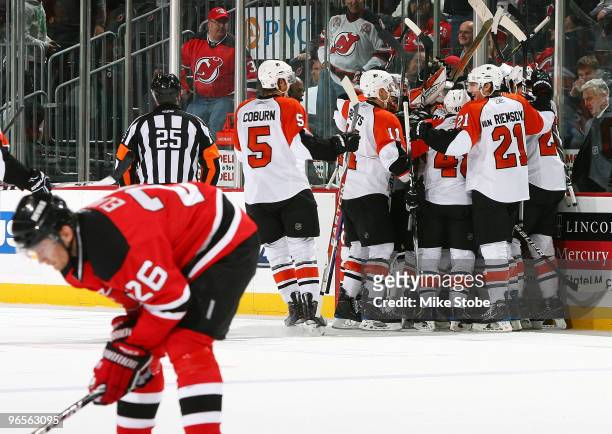 Simon Gagne of the Philadelphia Flyers is mobbed by his teammates after scoring the game-winning goal in overtime as Patrik Elias of the New Jersey...