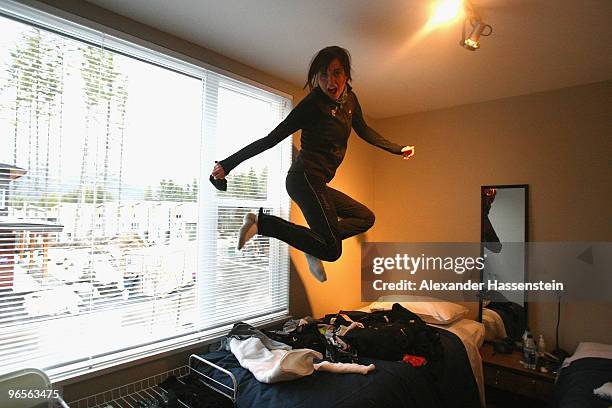 Biathlon athlete Sarah Murphy of New Zealand jumps on her bed at her suite at the Whistler Olympic village during the media tour ahead of the...