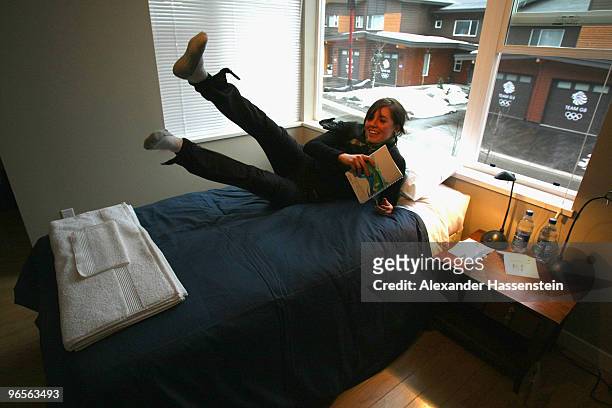 Biathlon athlete Sarah Murphy of New Zealand jumps on her bed at her suite at the Whistler Olympic village during the media tour ahead of the...