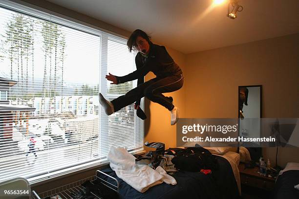 Biathlon athlete Sarah Murphy of New Zealand jumps on her bed at her suite at the Whistler Olympic village during the media tour ahead of the...