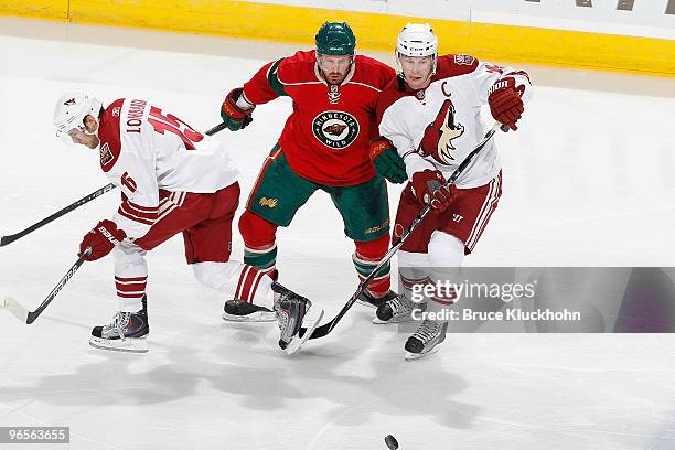 Greg Zanon of the Minnesota Wild battles for a loose puck with Matthew Lombardi and Shane Doan of the Phoenix Coyotes during the game at the Xcel...