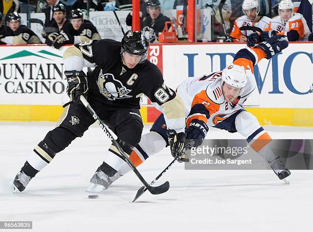 Sidney Crosby of the Pittsburgh Penguins moves the puck past the defense of Mark Streit of the New York Islanders on February 10, 2010 at Mellon...