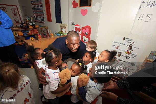 Former NBA player Dikembe Mutombo hugs some kids during the NBA Cares Community Caravan at the Vogel Alcove Childcare Center on February 10, 2010 in...