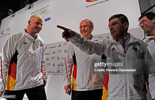 Three time Olympic gold medalist German bobsleder André Lange looks at Dr. Thomas Bach, a vice-president and member of the executive board of the...