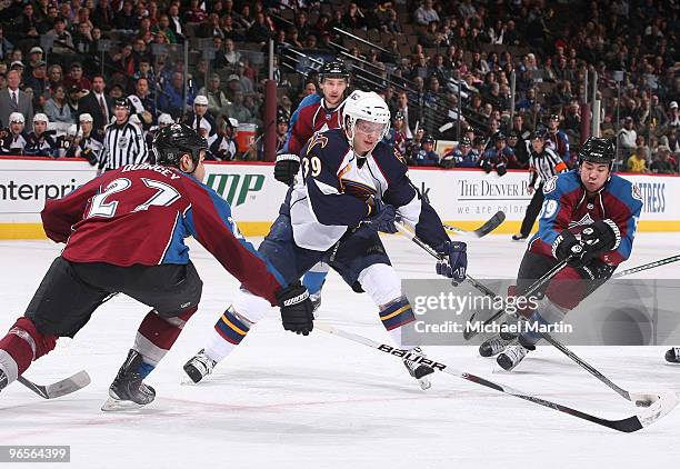 Tobias Enstrom of the Atlanta Thrashers skates with the puck against Kyle Quincey and Brandon Yip of the Colorado Avalanche at the Pepsi Center on...