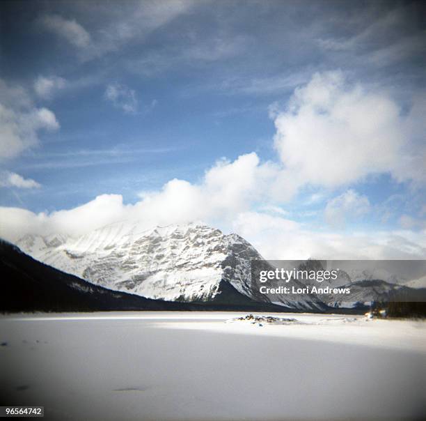 frozen kananaskis lake nestled in the mountains - lori andrews stock-fotos und bilder