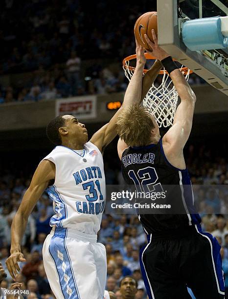 Duke forward Kyle Singler works to shoot the ball against North Carolina forward John Henson during a men's college basketball game at Dean Smith...