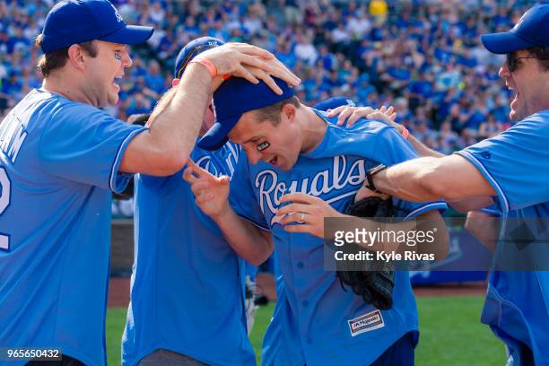 Celebrity participants congratulate Matt Besler after Besler hits a homer while taking part in the celebrity softball game at Kauffman Stadium during...