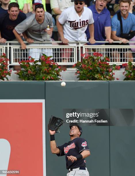 Michael Brantley of the Cleveland Indians makes a catching left field of the ball hit by Eddie Rosario of the Minnesota Twins as fans look on during...