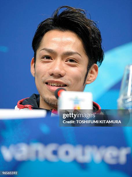 Japanese men's singles figure skater Daisuke Takahashi smiles while answering a question during the Japanese men's figure skating team press...