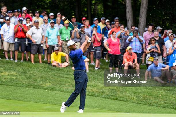 Tiger Woods hits his approach shot on the ninth hole fairway as fans watch during the second round of the Memorial Tournament presented by Nationwide...