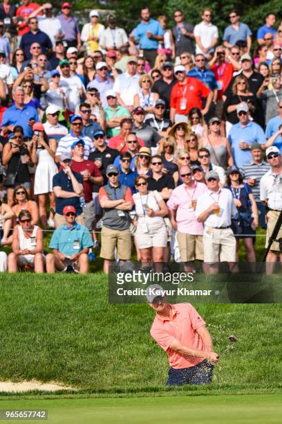 Justin Rose of England hits out of a greenside bunker on the 14th hole as fans watch during the second round of the Memorial Tournament presented by...