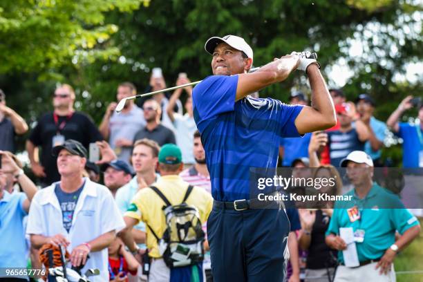 Tiger Woods tees off with a 7-iron on the 16th hole as fans watch during the second round of the Memorial Tournament presented by Nationwide at...