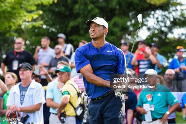 Tiger Woods tees off with a 7-iron on the 16th hole as fans watch during the second round of the Memorial Tournament presented by Nationwide at...