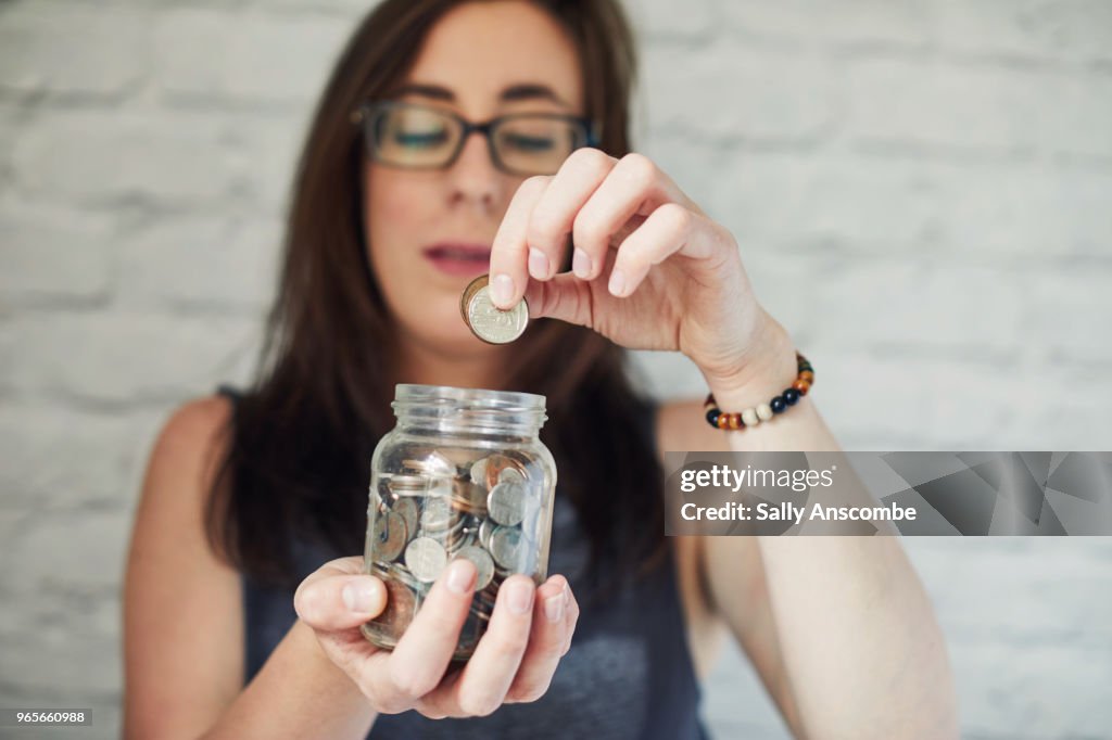 Woman holding a jar of money