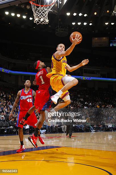 Stephen Curry of the Golden State Warriors twists around for a layup against Baron Davis of the Los Angeles Clippers on February 10, 2010 at Oracle...