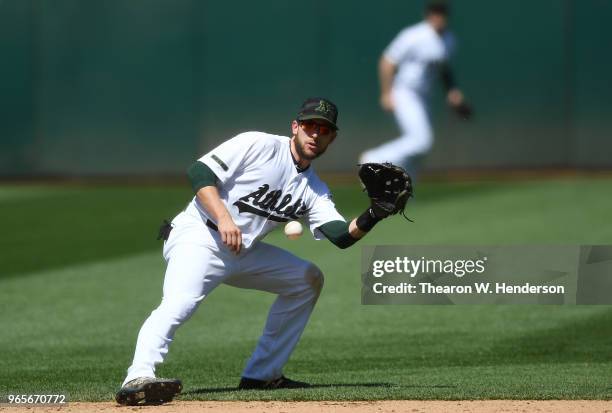 Jed Lowrie of the Oakland Athletics goes down to field a ground ball off the bat of C.J. Cron of the Tampa Bay Rays in the top of the ninth inning at...