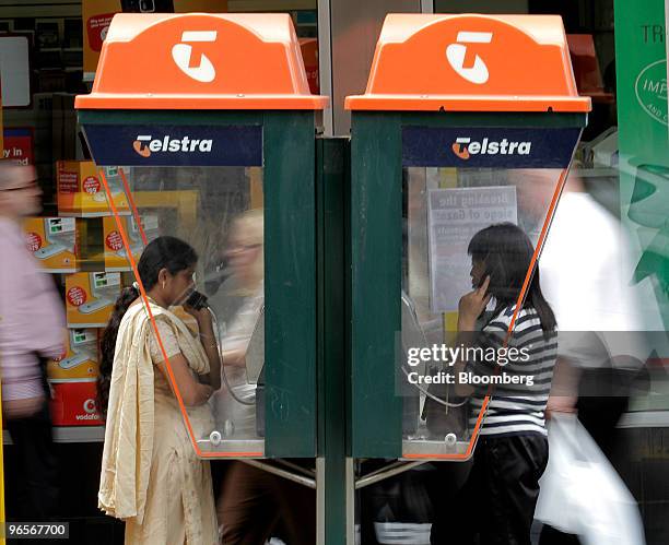 People talk on Telstra Corp. Pay phones in Melbourne, Australia, on Thursday, Feb. 11, 2010. Telstra Corp., Australia's largest phone company, cut...