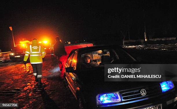 Romanian customs officer stops a car before searching it for smuggled products, like cigarettes and alcohol, on the road to the city of Iasi, 400 kms...