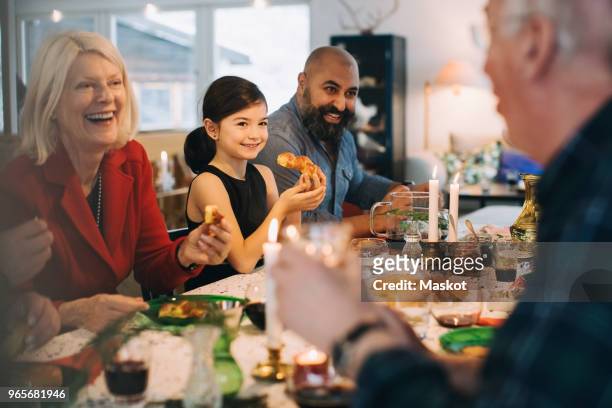 Happy multi-generation family enjoying meal at table during Christmas