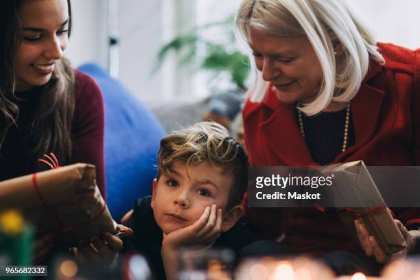 multi-generation family with christmas presents sitting in living room - national day in sweden 2017 stock pictures, royalty-free photos & images