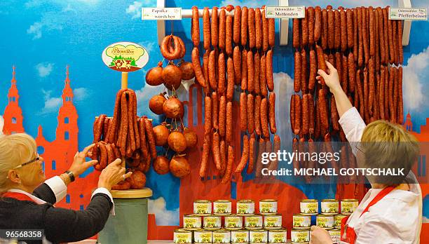 Fair vendors arrange sausages from the Odenwald region, western Germany, at their stand at the International Green Week Food and Agriculture fair in...