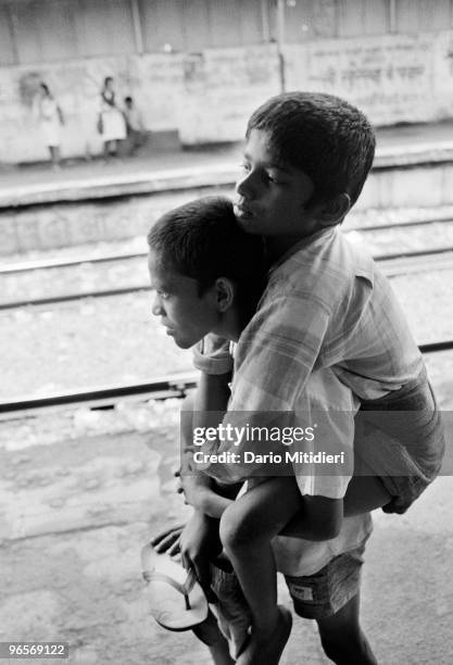 Street child Annu carrying his friend Gangaram who suffers from polio, at Victoria Terminus Station.